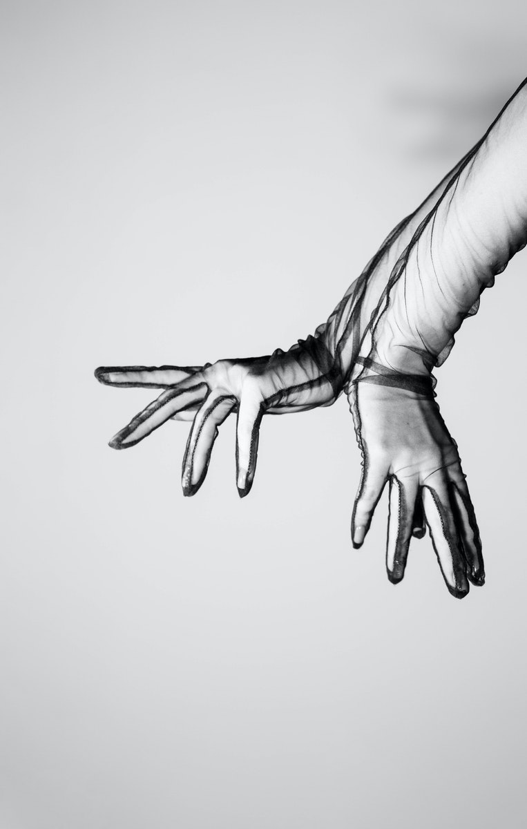 Black and White Photo of Hands in Transparent Gloves